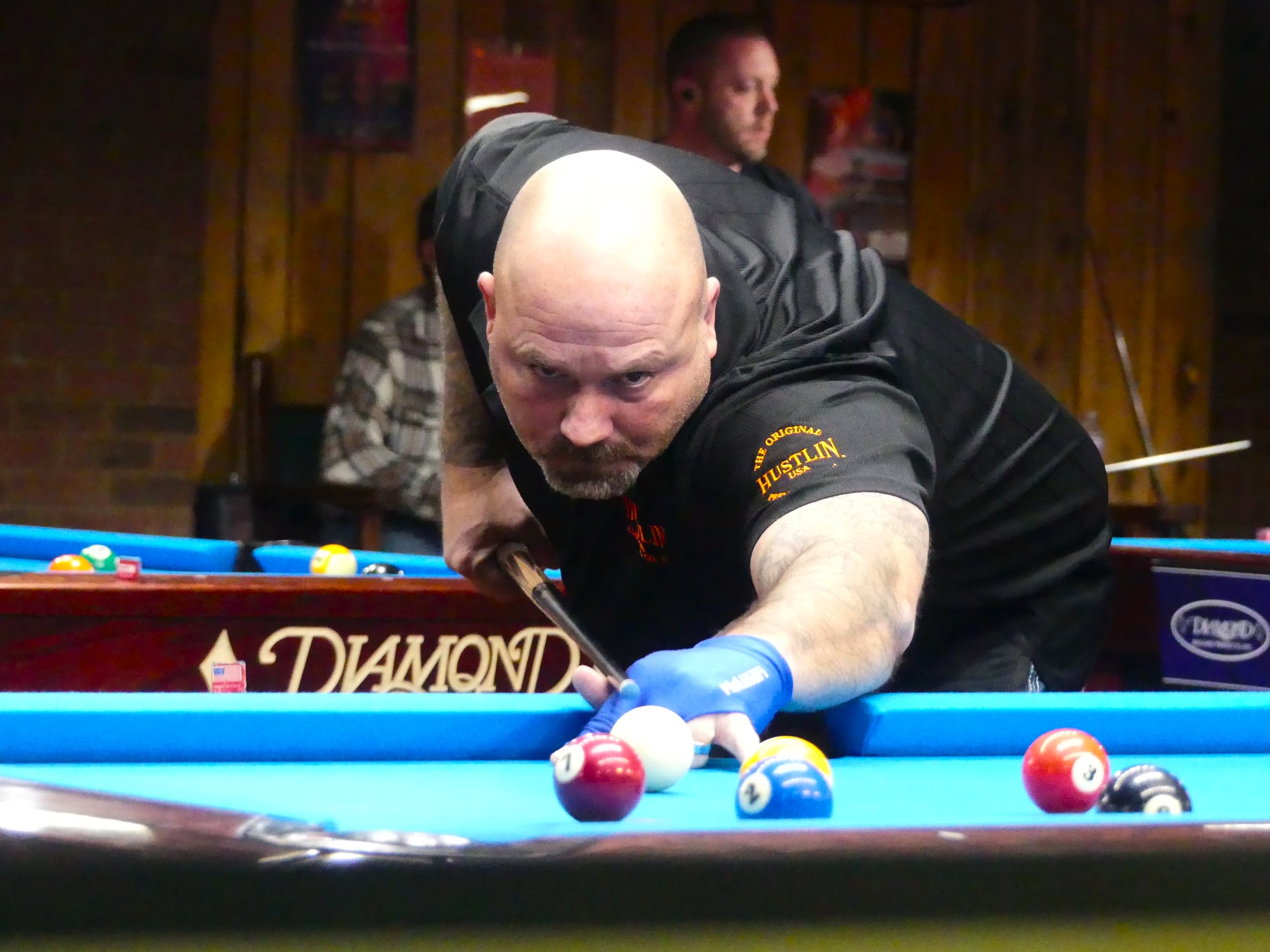 Pool player competing on a blue tournament table